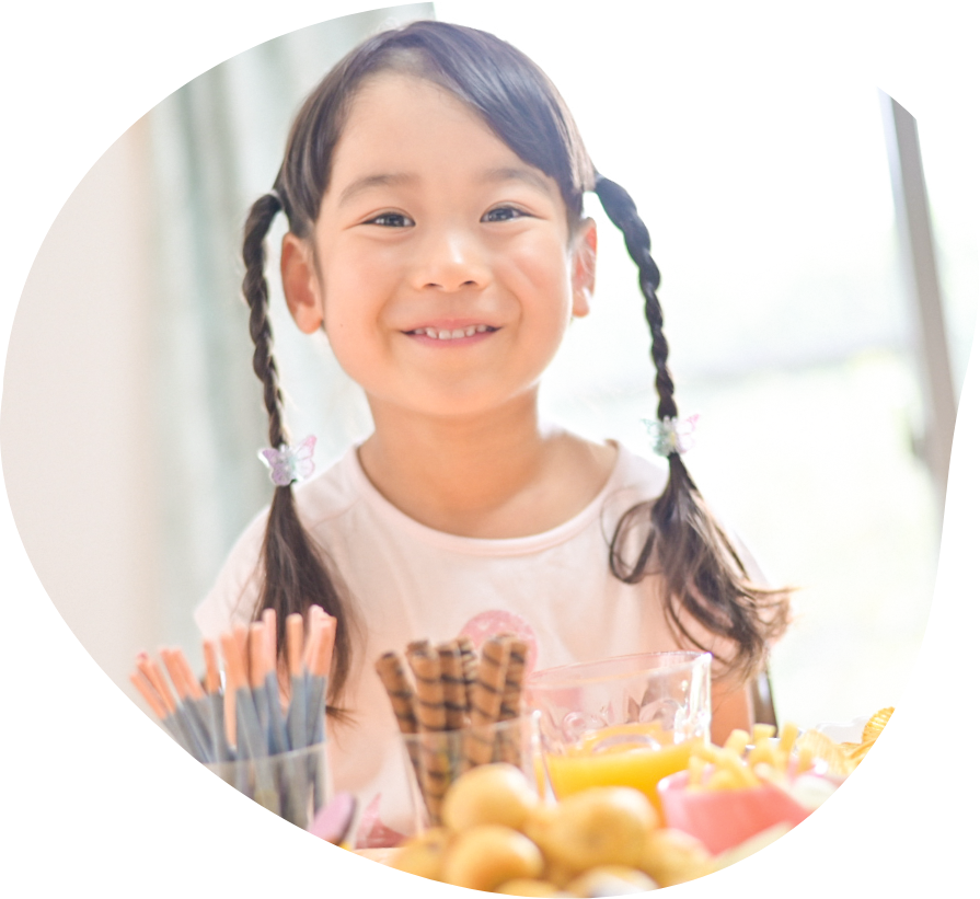 お菓子を前に笑顔の子ども